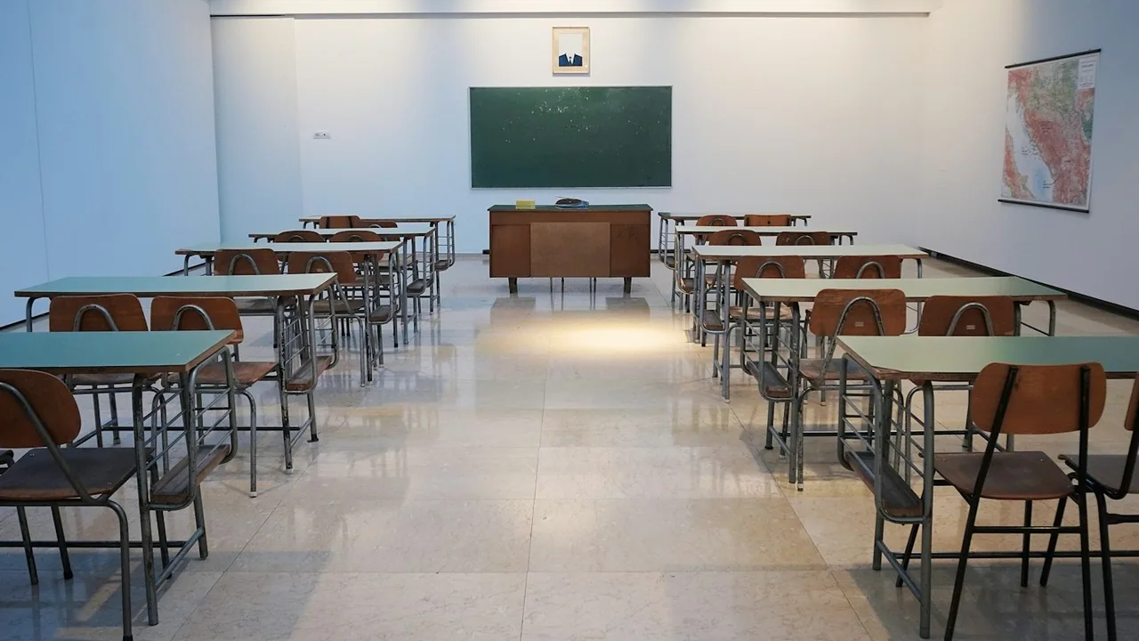 فصل دراسي خالٍ تتوزع فيه المقاعد أمام السبورة