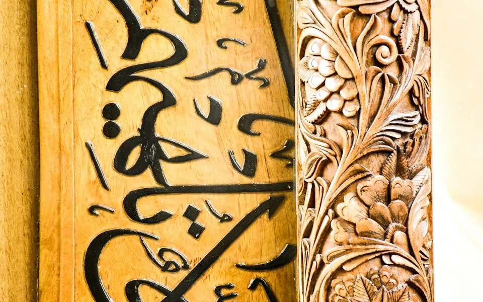 خط عربي وزخرفة على لوح خشبي